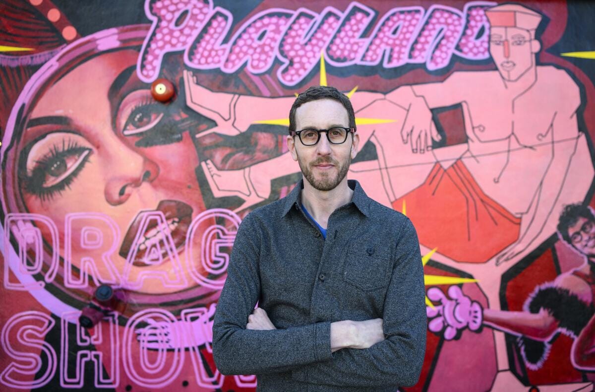 State Sen. Scott Wiener stands in front of a mural at Oasis, a drag club he helped the owners launch in San Francisco. 