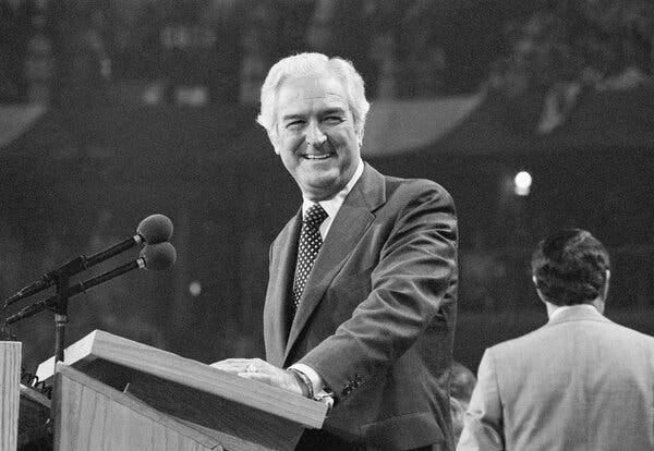 John B. Connally Jr. smiling while standing at a podium.