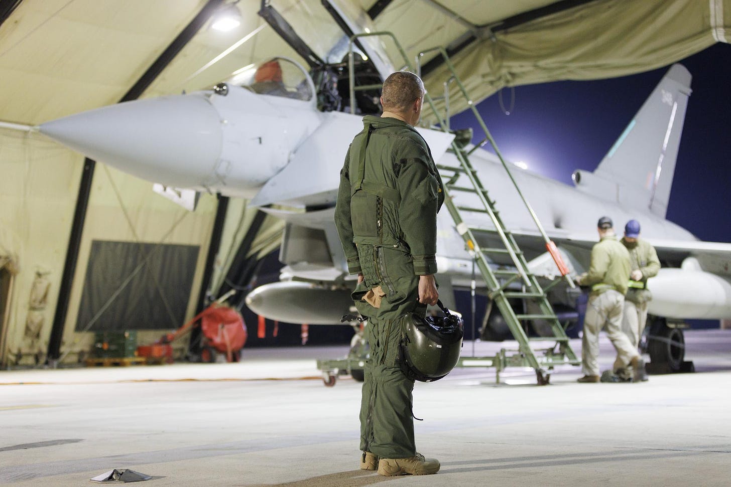 A soldier stands in front of an RAF Typhoon FGR4 aircraft.