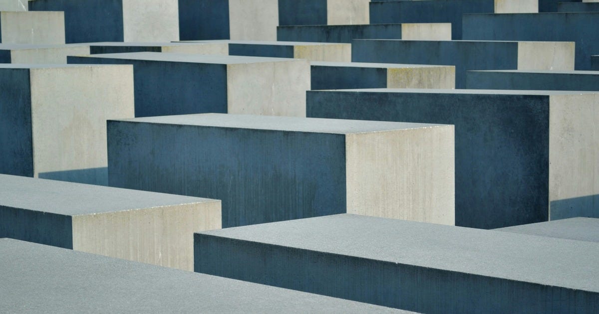 An image of Berlin's Holocaust memorial, a disorienting labyrinth of concrete blocks lacking markers to help situation someone walking through them.