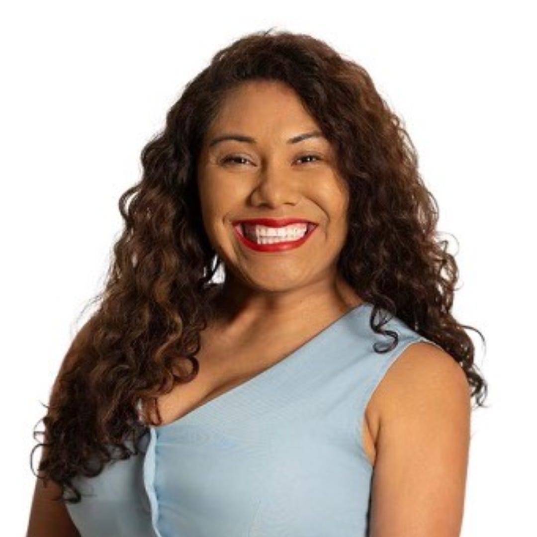 Sandra N. Aguirre smiling for a headshot, wearing a light blue dress.