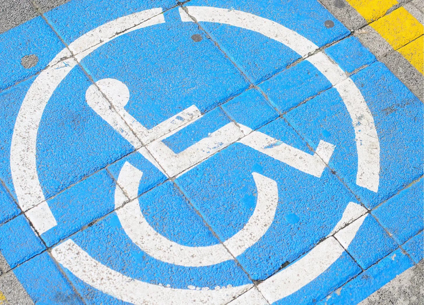 Wheelchair symbol painted on a cement tiled surface