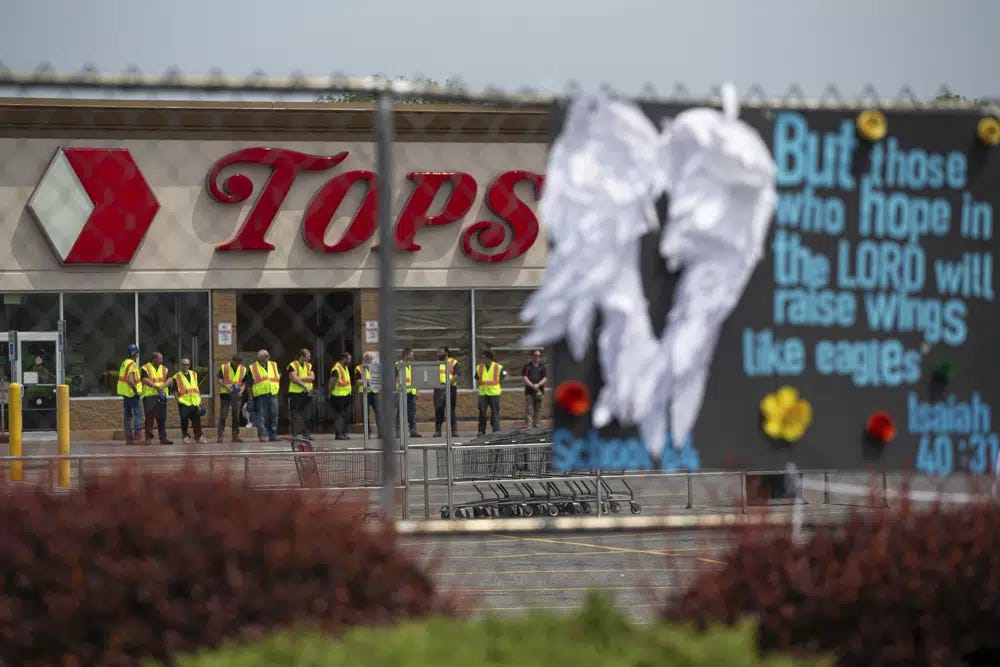 FILE - Investigators stand outside during a moment of silence for the victims of the Buffalo supermarket shooting outside the Tops Friendly Market on May 21, 2022, in Buffalo, N.Y. The number of U.S. mass killings linked to extremism was at least three times higher in the last decade than the total from any 10-year period since the 1970s. That's according to a report released to The Associated Press by the Anti-Defamation League. (AP Photo/Joshua Bessex, File)
