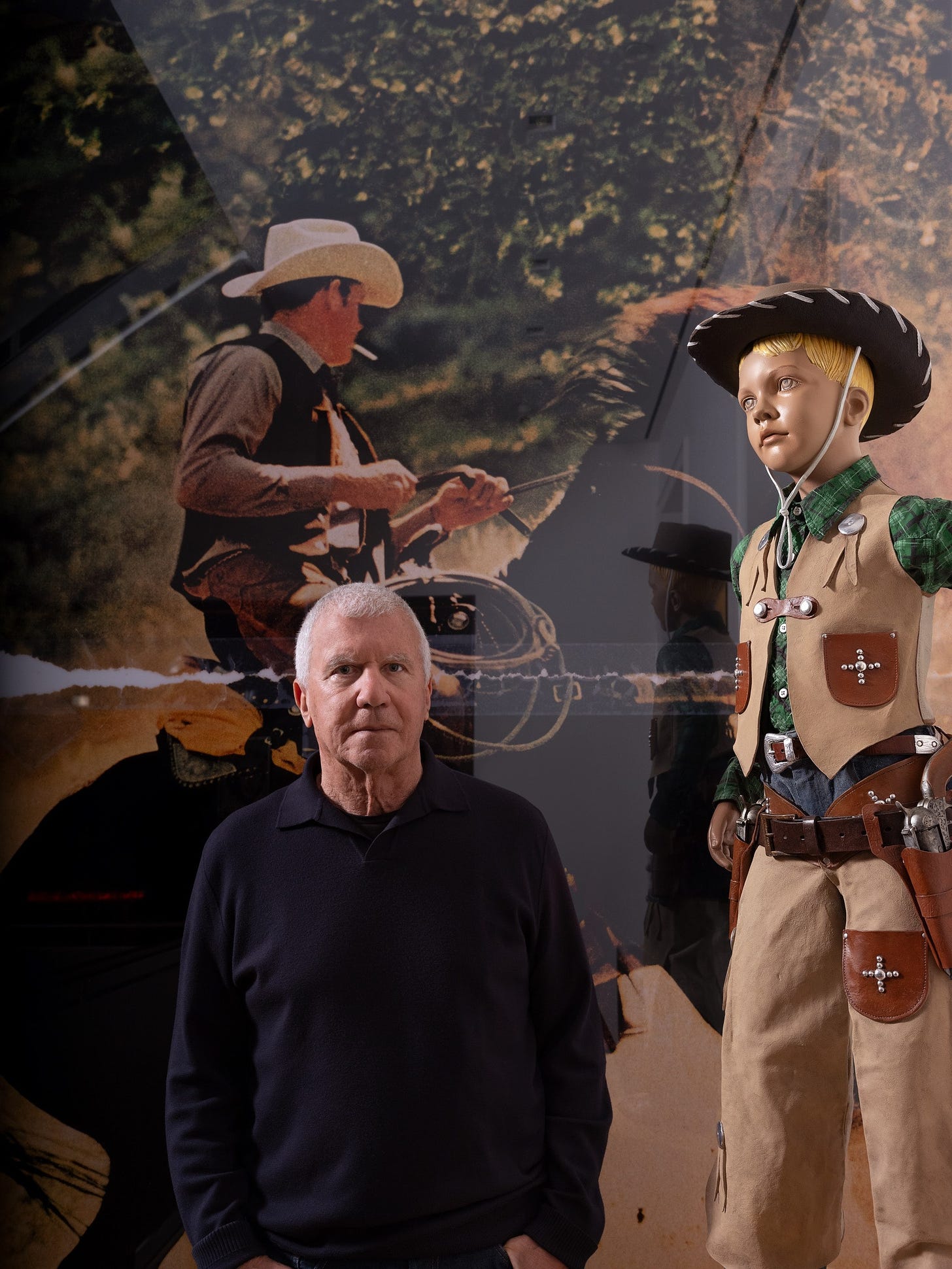 Larry Gagosian stands in front of art by Richard Prince.