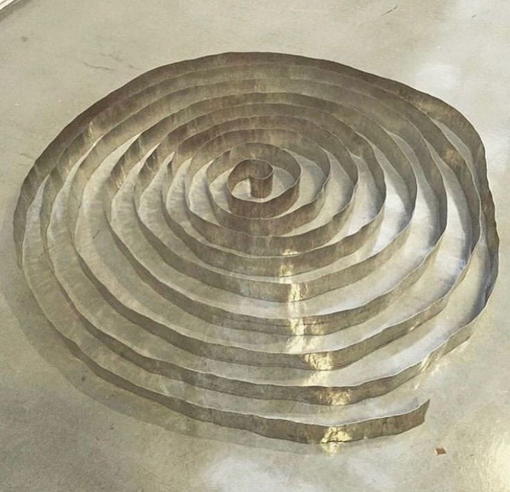 This may contain: a circular metal object sitting on top of a floor