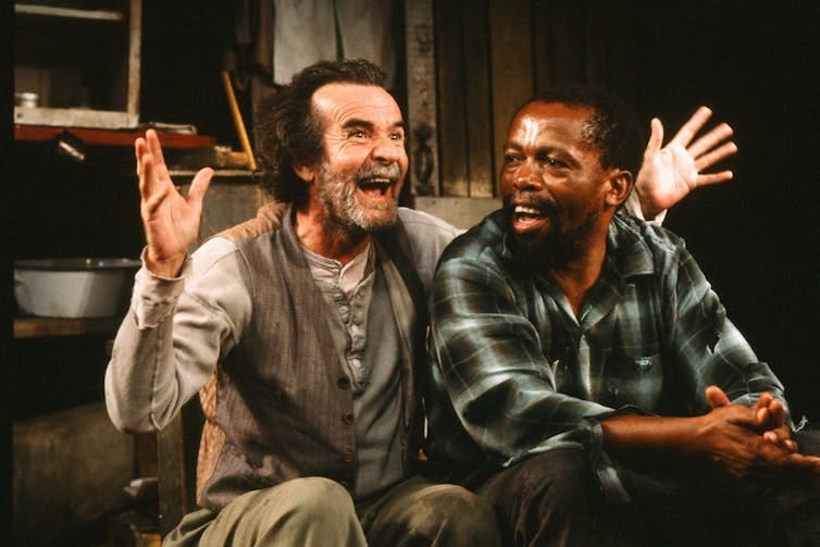 Two men, one Caucasian and one African, on a stage.
