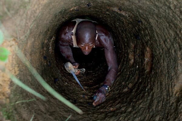 A man is seen from above in a narrow tunnel.