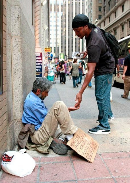 A pedestrian gives money to a homeless man sitting outside St. Francis of Assisi Church in New York City in 2009. How Christians treat the poor is the clearest demonstration of their relationship with God, Pope Francis said May 18 during his weekly general audience.