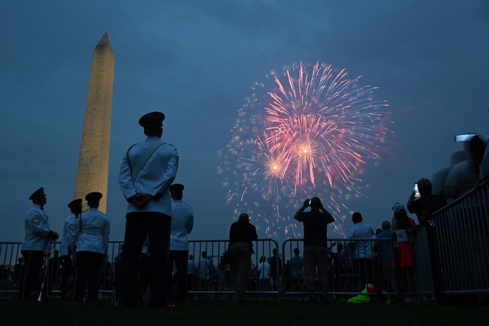 A spectator watches as fireworks fill the sky following the parade