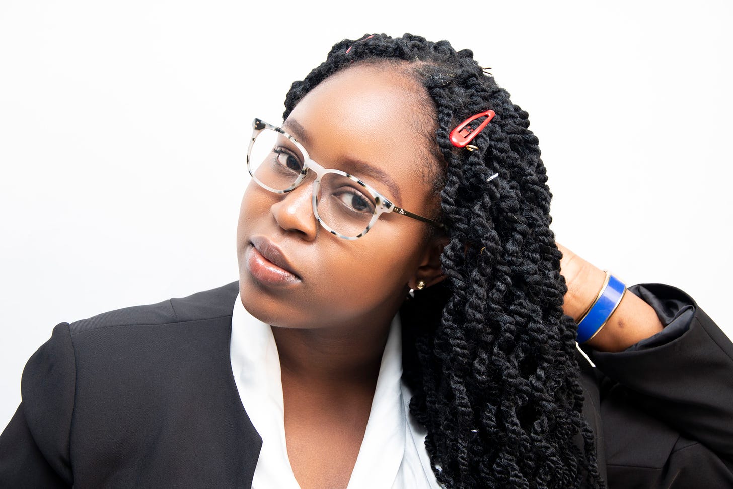 Headshot of Tolulope, a Nigerian woman with glasses and long black hair wearing a black suit