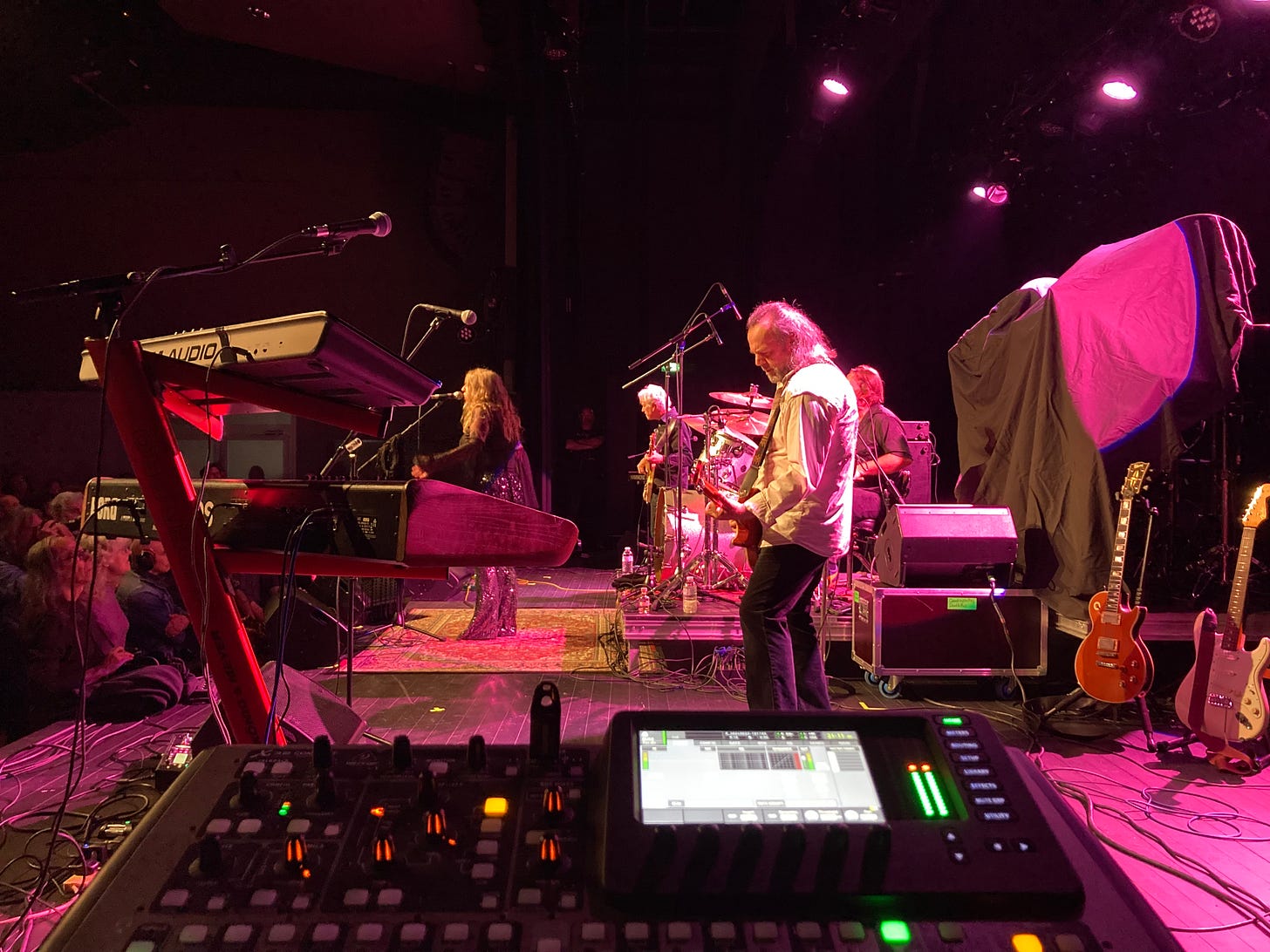 Onstage view from Steve's console of the Deborah Bonham band, with pink lighting and Bonham in her signature bare feet on a carpet, centre stage.