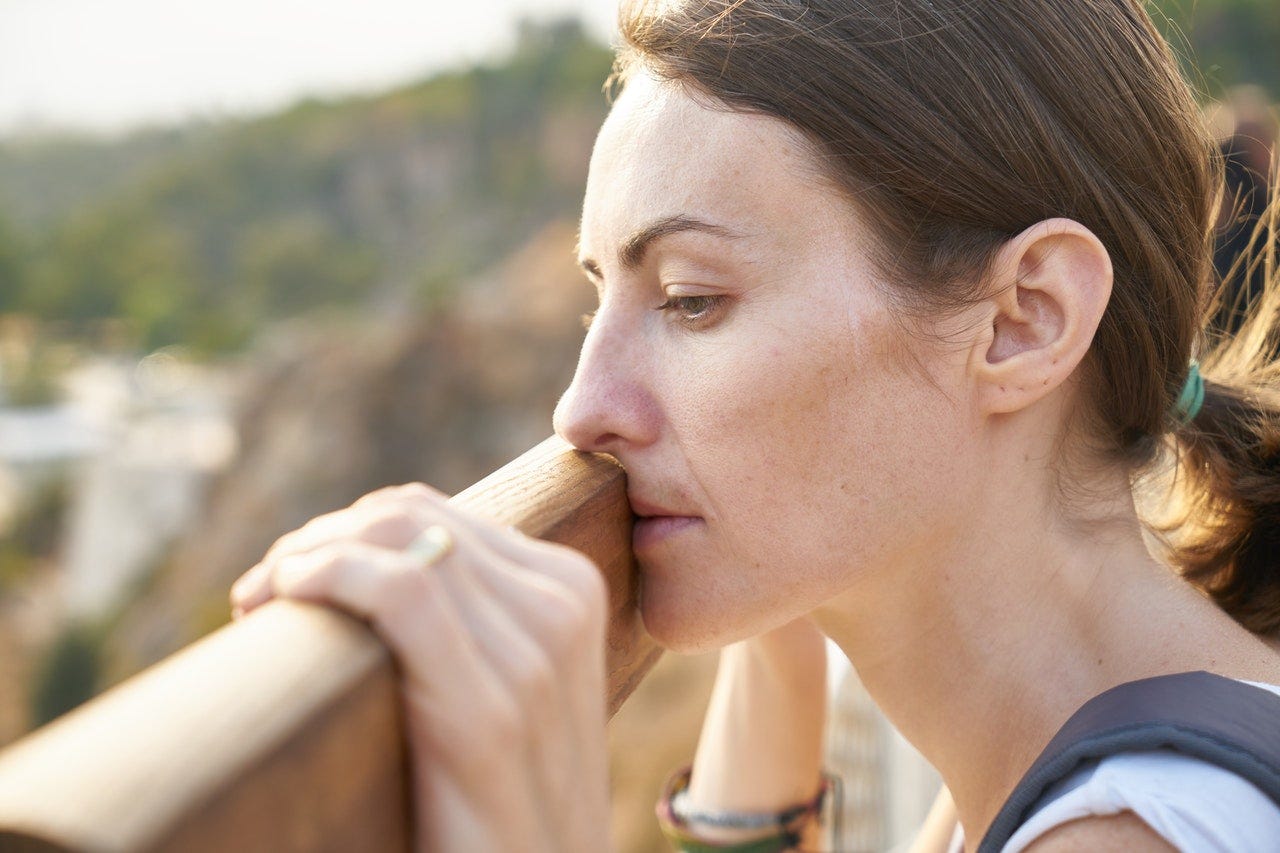 woman looking down from bridge with sad symtoms