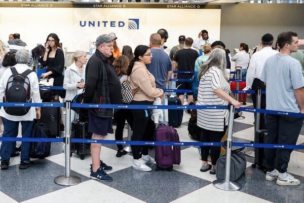People waiting in line at a United counter at O’Hare International Airport in Chicago.