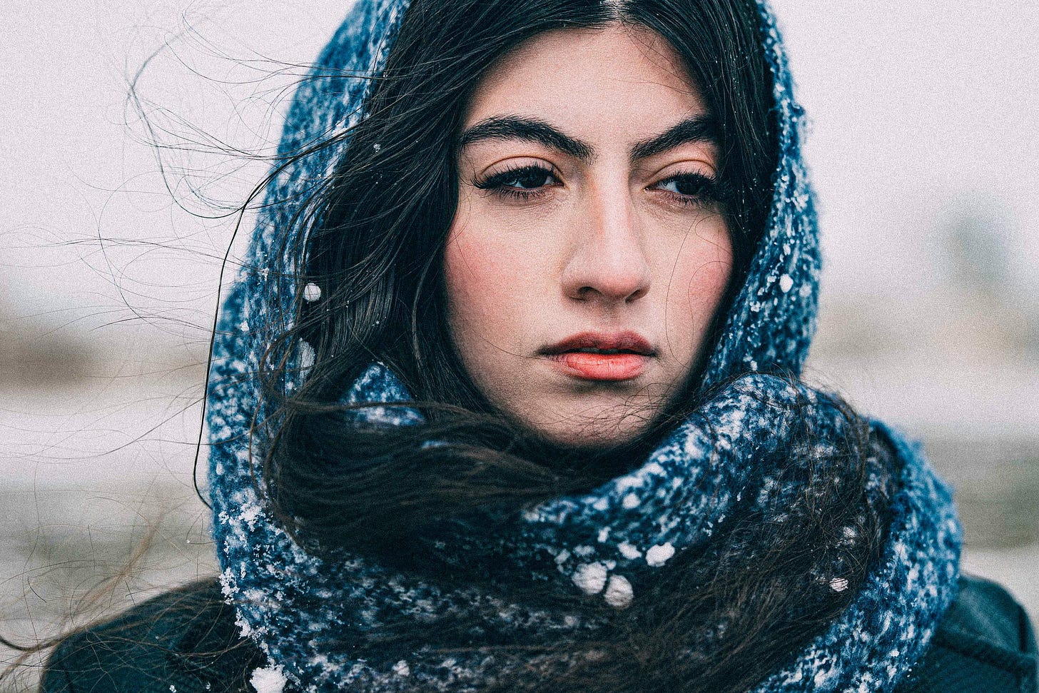 Woman with a blue scarf wrapped around her hair