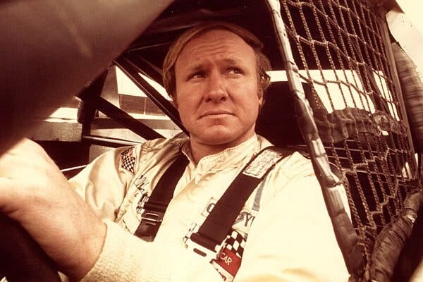 A young Cale Yarborough sits behind the wheel of his racecar.