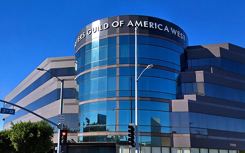 This image shows a photo of the Writers Guild of America West Building, located at 7000 West 3rd Street in Los Angeles, California. The blue sky is reflected in the edifice's many windows.