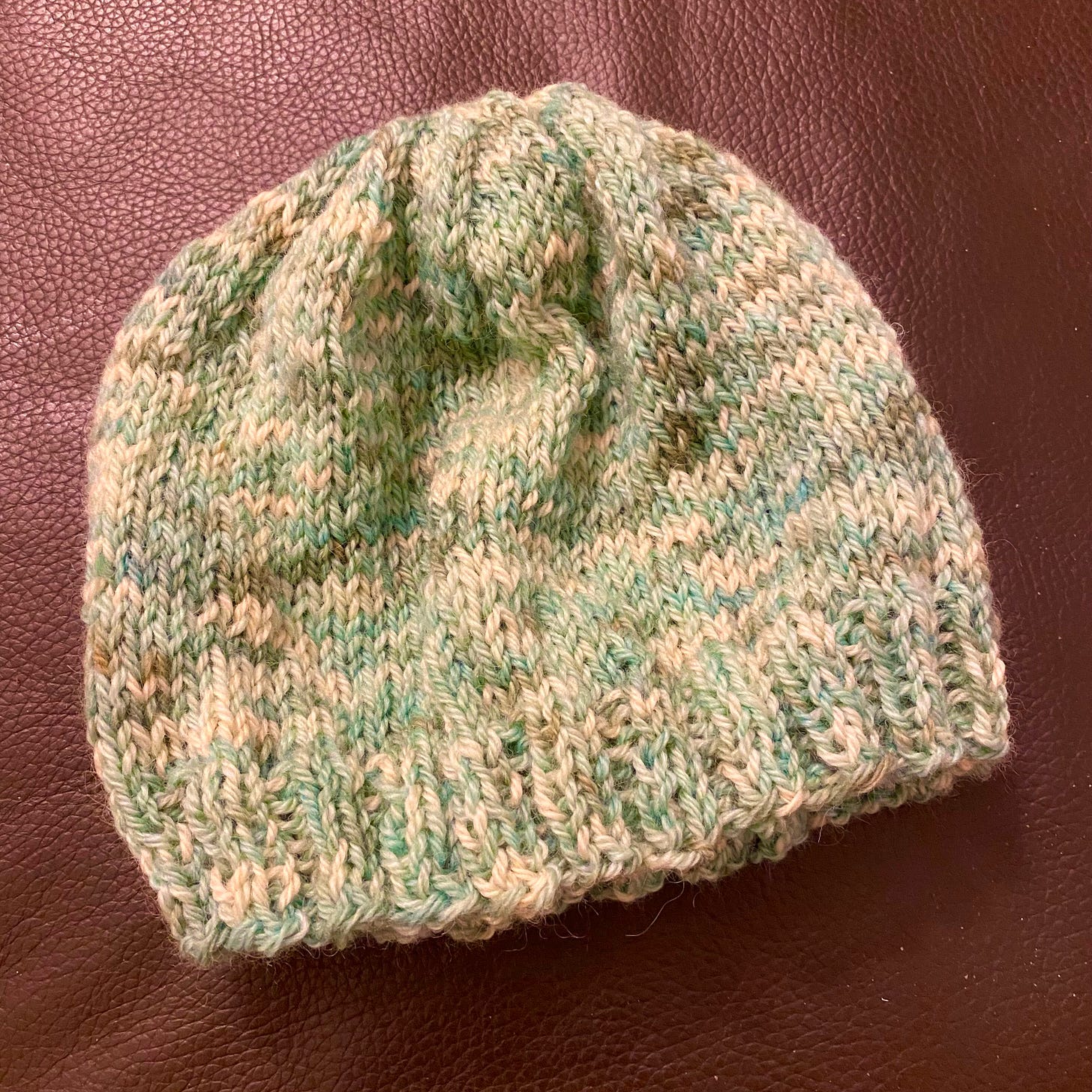 Heathery green and taupe knitted beanie.