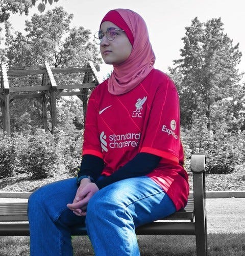 Ayah captured in profile, red shirt, jeans, hijab