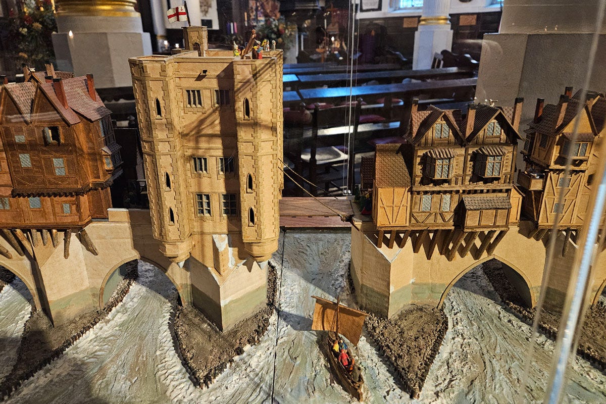 A model of a bridge over a river which features a large gatehouse and drawbridge