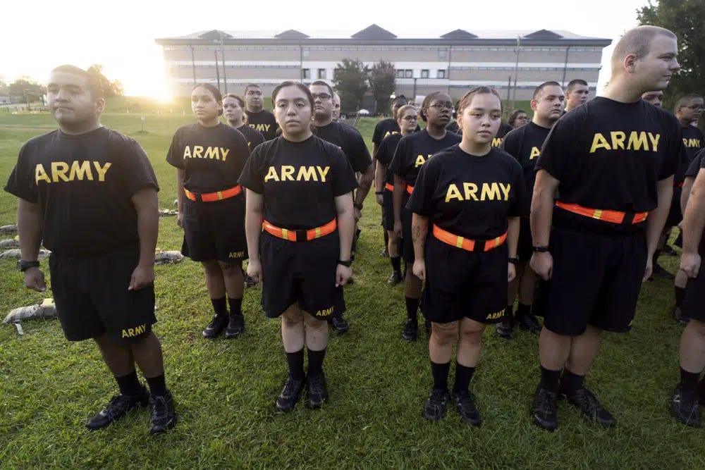 FILE - Students in the new Army prep course stand at attention after physical training exercises at Fort Jackson in Columbia, S.C., Aug. 27, 2022. The Army is trying to recover from its worst recruiting year in decades, and officials say those recruiting woes are based on traditional hurdles. The Army is offering new programs, advertising and enticements to try to change those views and reverse the decline. (AP Photo/Sean Rayford, File)