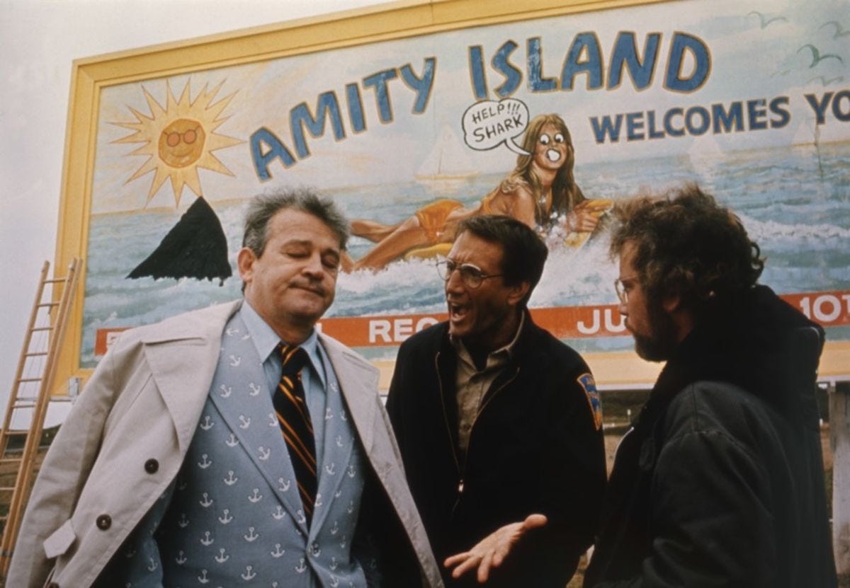 A still from Jaws, with actors Murray Hamilton, Roy Scheider, and Richard Dreyfuss. Roy is yelling at Hamilton, the mayor, about what's waiting in the water for the people of Amity Island. The mayor is over it.