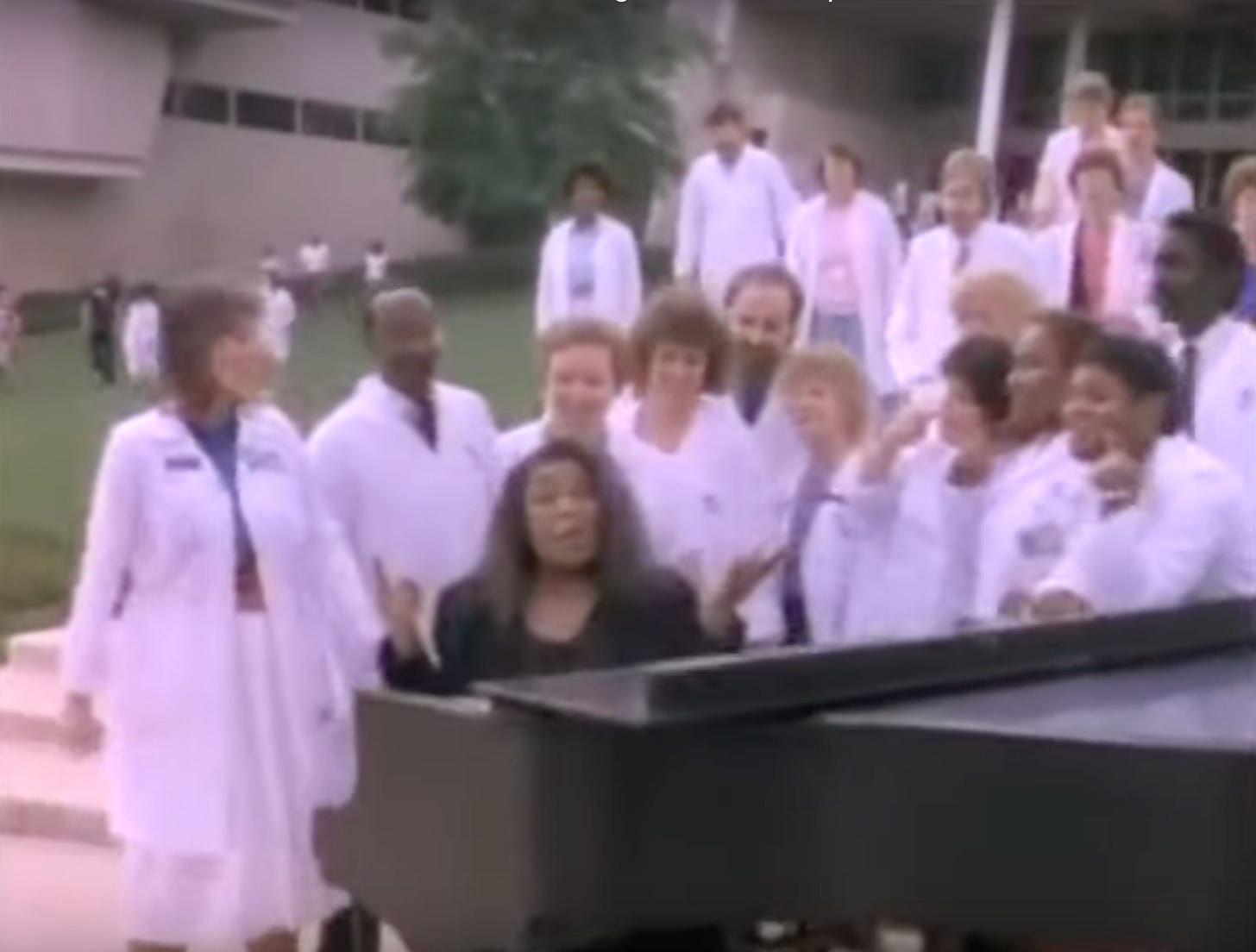 Roberta Flack at a piano in front of a building