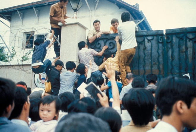 Desperate South Vietnamese citizens try to scale the walls of the American Embassy in a vain attempt to flee Saigon and advancing North Vietnamese troops on Aprl 29, 1975.
