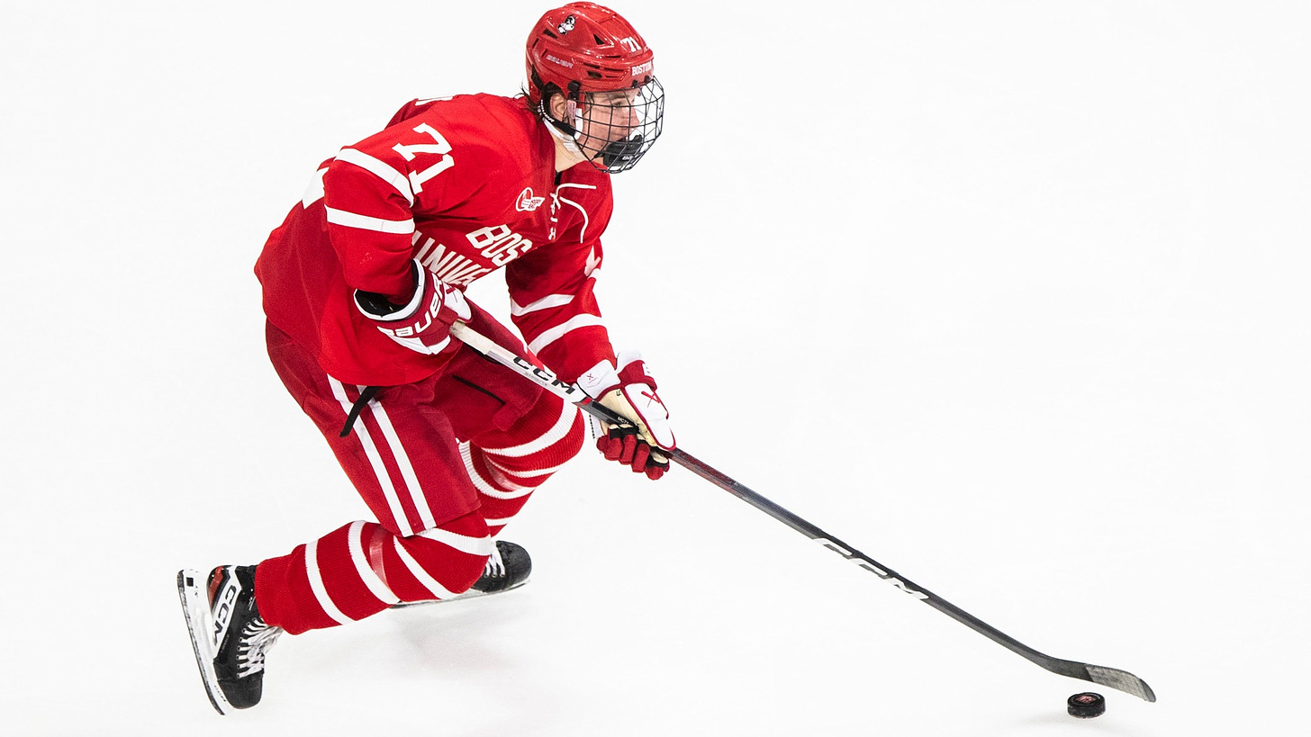 Macklin Celebrini skating down the ice with the puck on his stick during a game for Boston University.