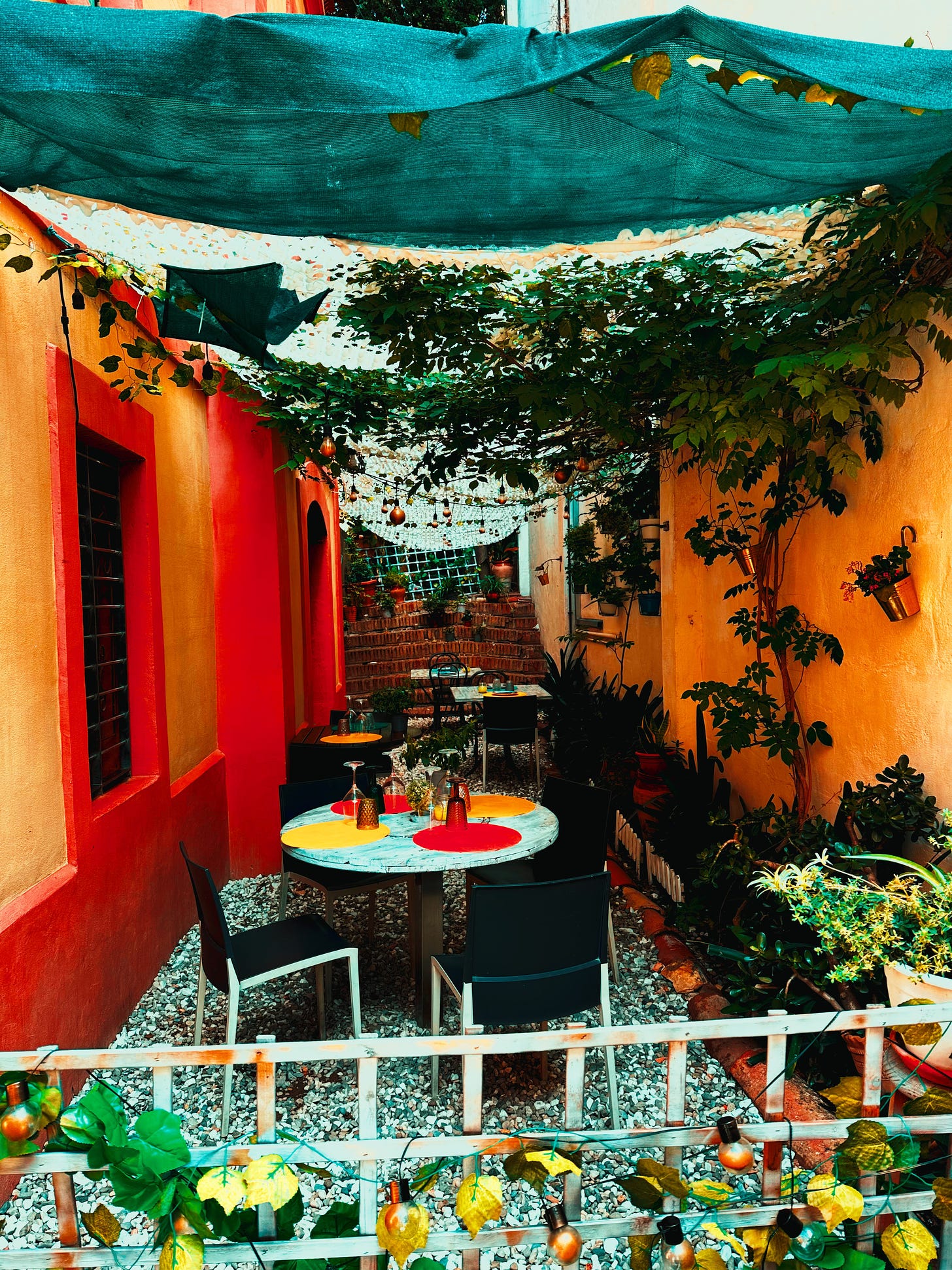 A Hidden Oasis-  Tucked away in a colourful Sitges alley, this cozy patio invites quiet moments beneath the vines.