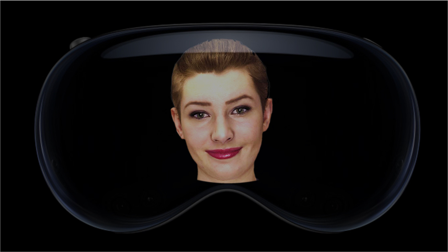 Black background. Image of transparent VR headset with an image of Nadia the avatar's face. Image of Nadia is a female, short dark hair, fair skin, red lips, hazel coloured eyes, smiling.