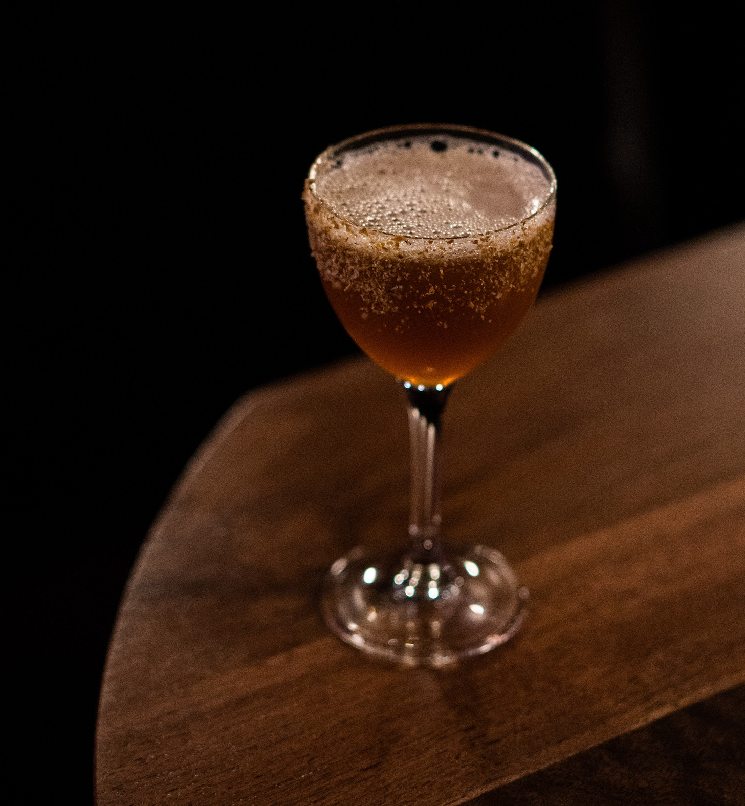 Photo of shaken cocktail (medium-brown) in a stemmed nick and nora glass