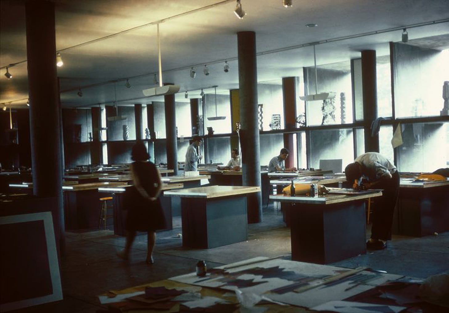 Students working over tables in dim lighting