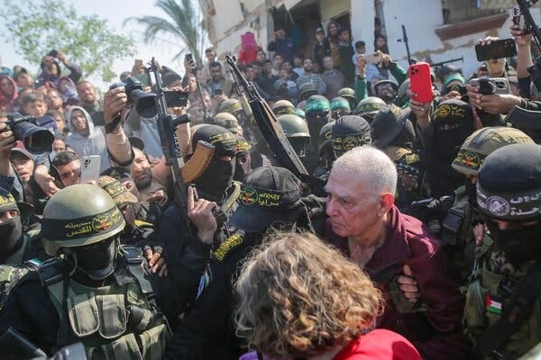 Gadi Moses is escorted by several armed fighters amid a thick throng of people.