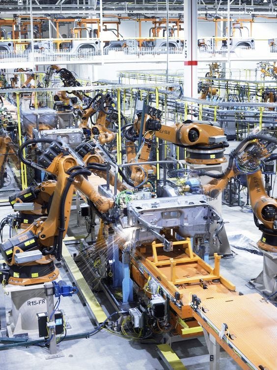 This may contain: an assembly line with several robots working on the assembly line and machinery in the background