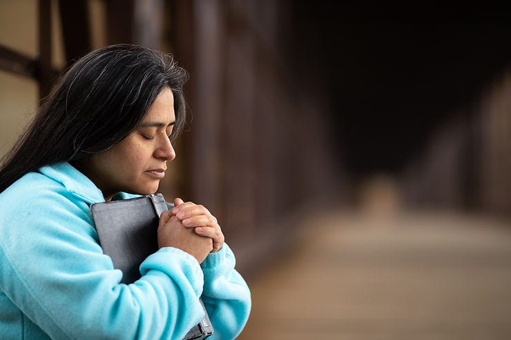 woman praying with bible