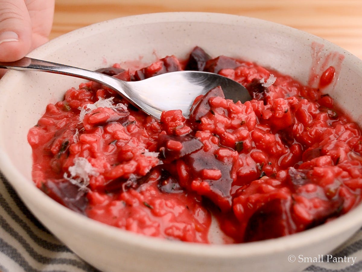 Close up of beet risotto in a white bowl.