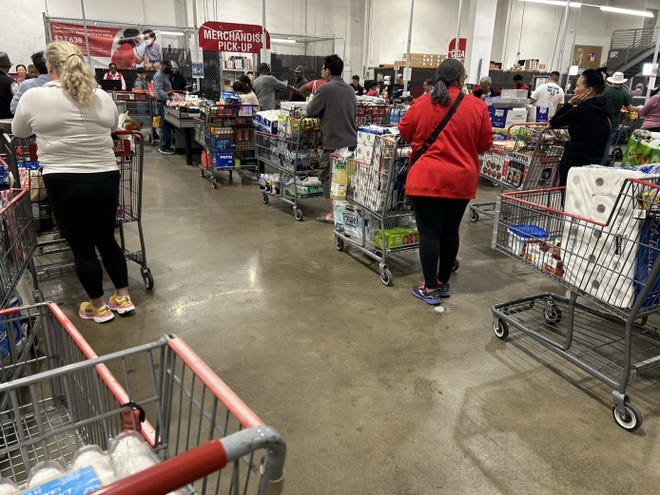 Shoppers at a Costco in Arlington, Virginia, wait to check out with essentials such as toilet paper and paper towels after the East Coast port strike began.