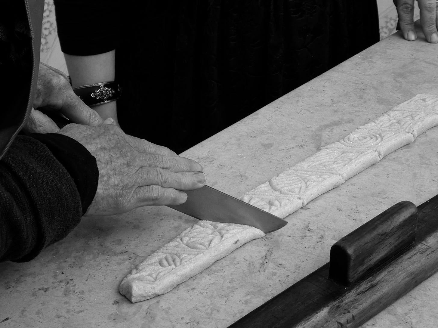 hands cutting makroudh with a big knife