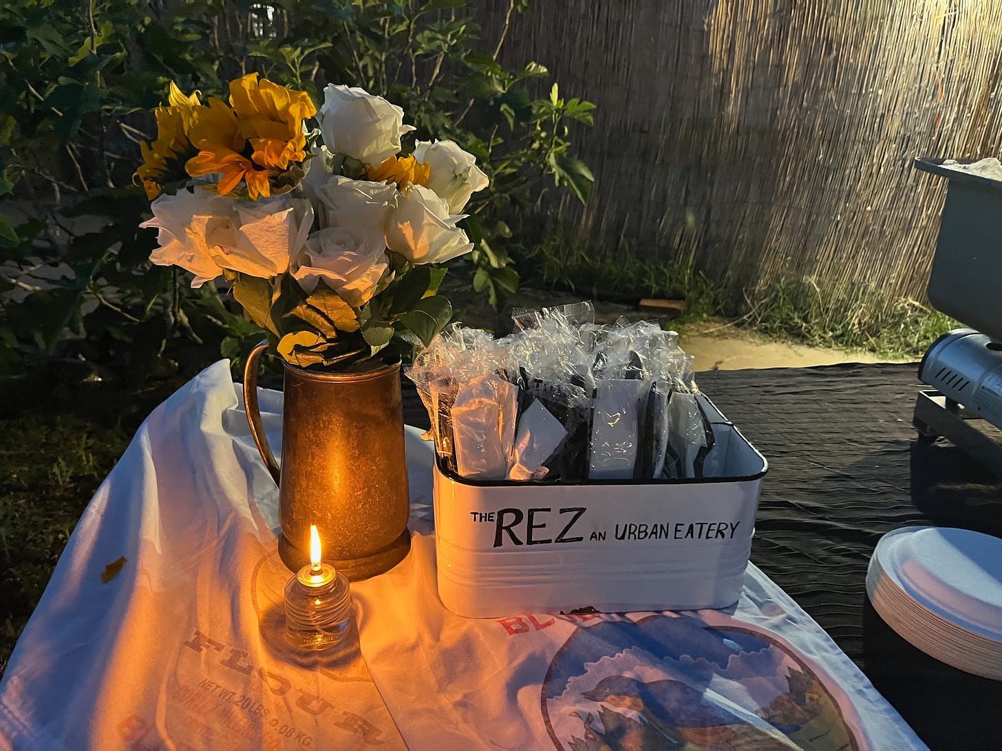 The Rez An Urban Eatery's catering table at the event with sunflowers and roses and candles