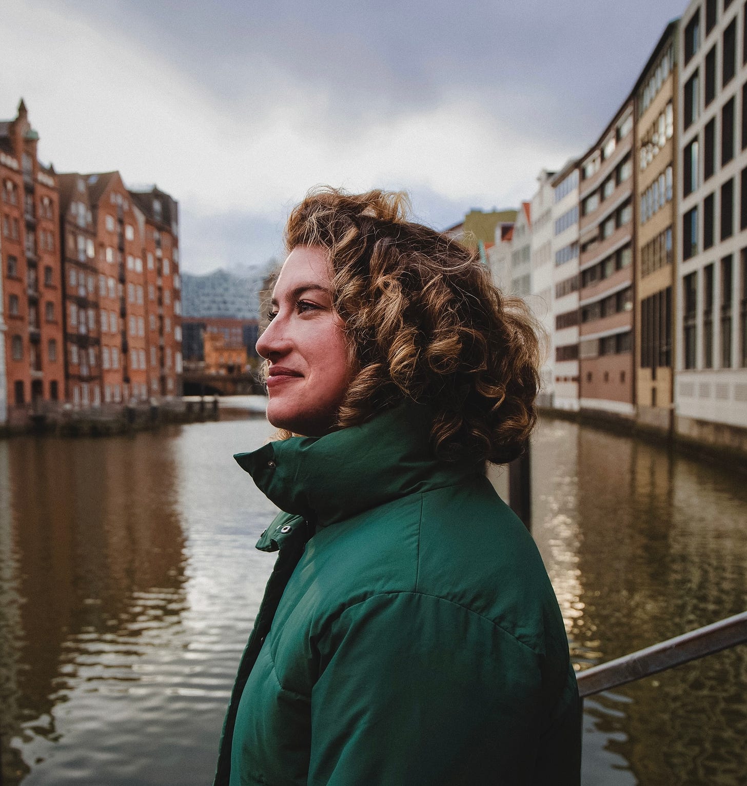 Maeve standing in the Speicherstadt district of Hamburg, looking off in the distance