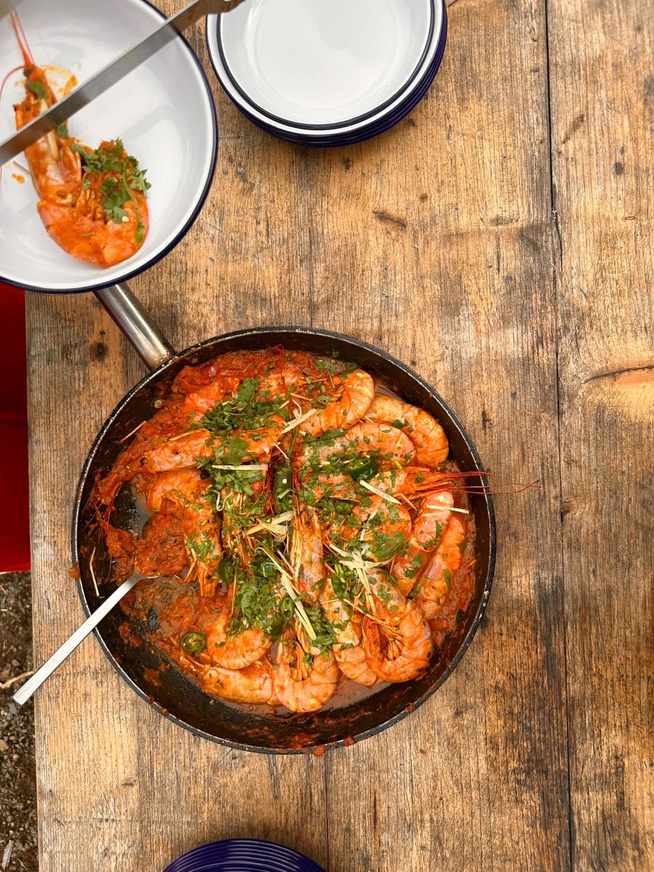 cast iron pan full of cooked whole prawns in a spicy tomato sauce cooked by Sumayya Usmani