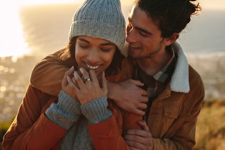 Man and woman in warm outdoor clothing embracing