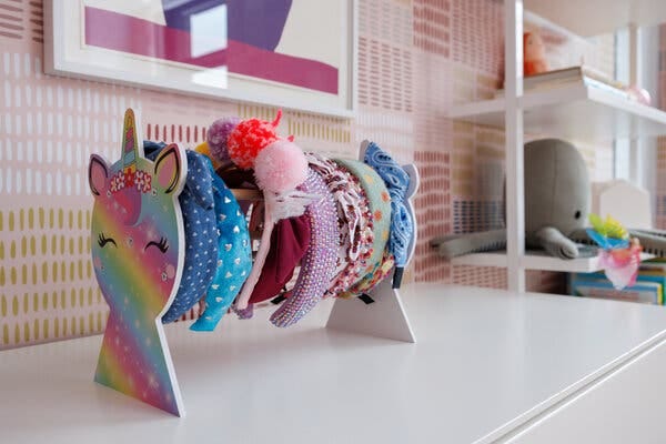 A unicorn-themed stand holds colorful headbands.