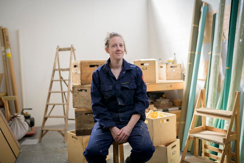 Sculptor Jo Lathwood surrounded by wood and wooden boxes