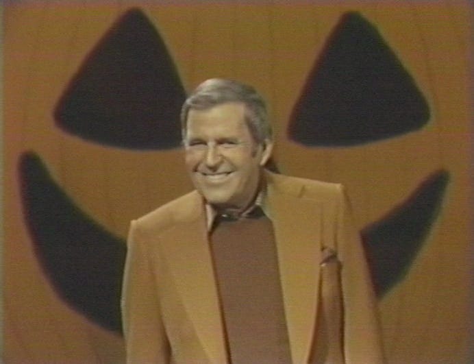 Paul Lynde smiling in front of a big jack o' lantern background, a screenshot from his Halloween special