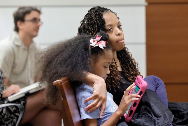 Philana Holmes and her daughter Olivia Caraballo, 7 listen to the final witness in their case at the Broward County Courthouse in Fort Lauderdale on Wednesday May 10, 2023. McDonald’s and a franchise holder are at fault after a hot Chicken McNugget from a Happy Meal fell on the girl's leg and caused second-degree burns, a jury in South Florida has found, Thursday, May 11.  (Mike Stocker/South Florida Sun-Sentinel via AP) ORG XMIT: FLLAU102