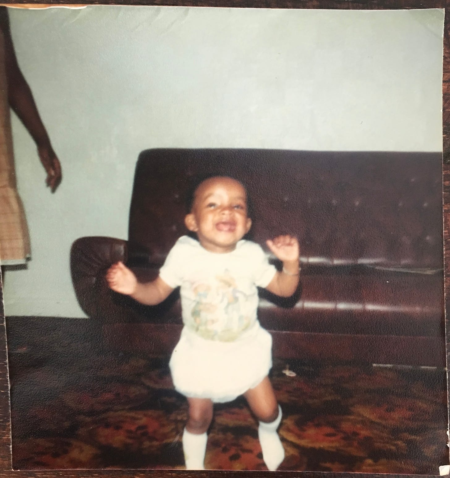 Baby Nat Lue in a white tee, bloomers and knee socks