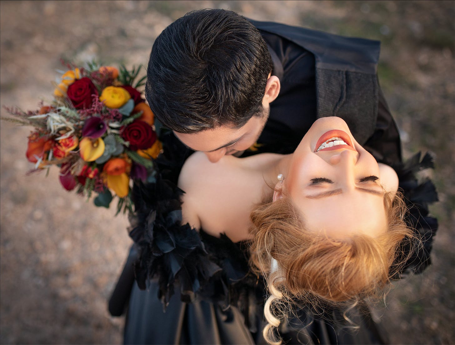 Man w/ flowers kissing woman on bare shoulder