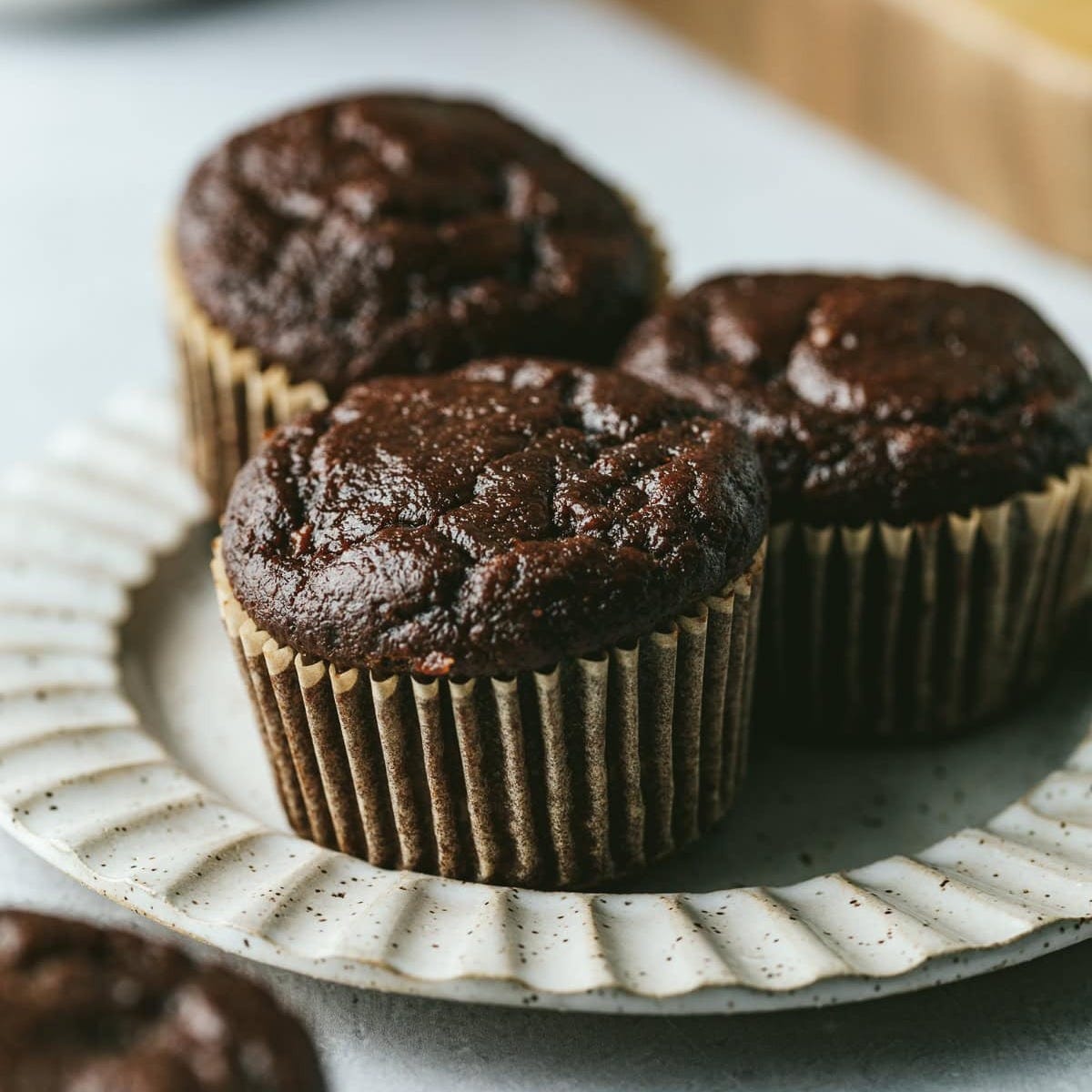 Chocolate banana protein muffins on a plate.