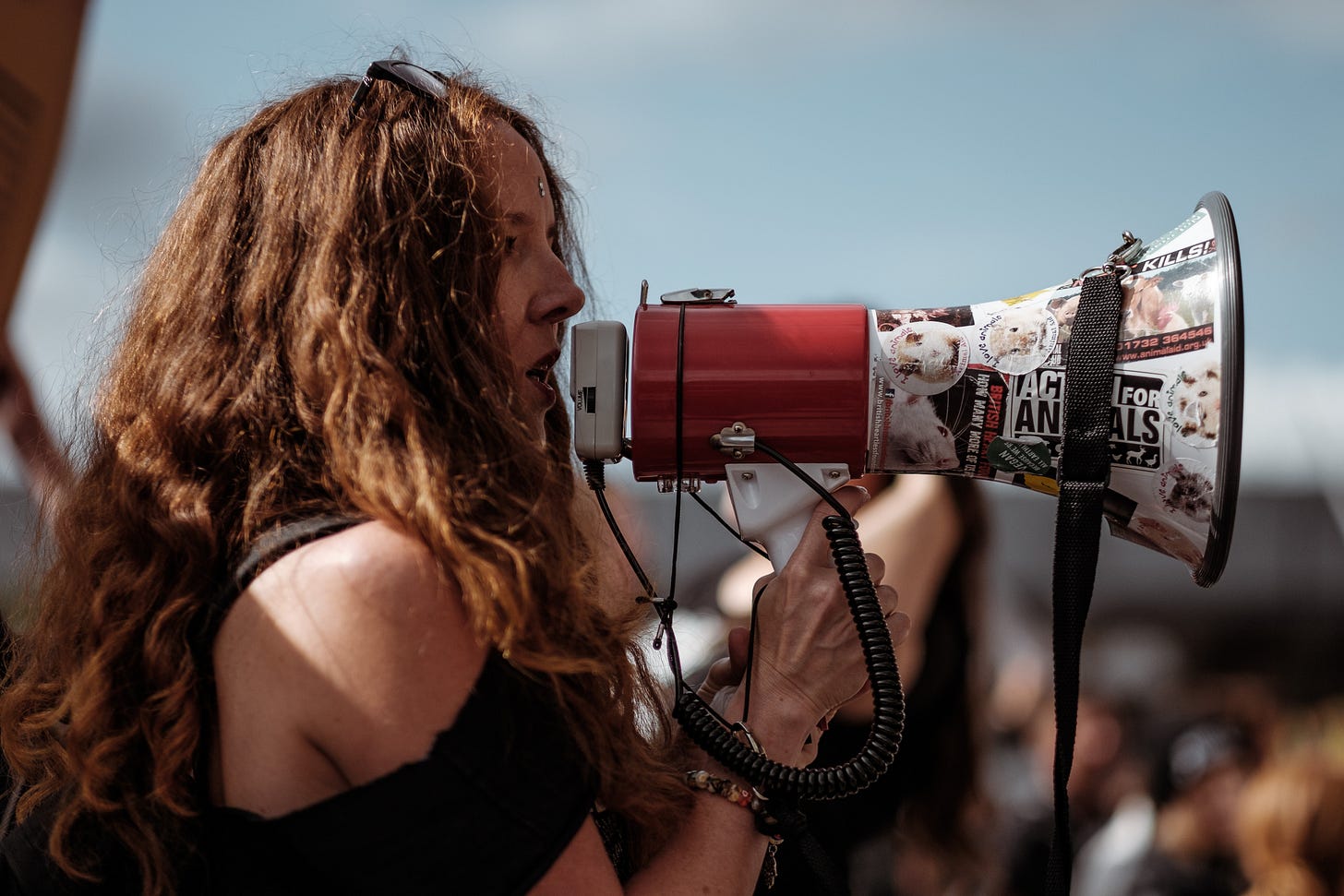 protester with a megaphone, byClem Onojeghuo via Unsplash